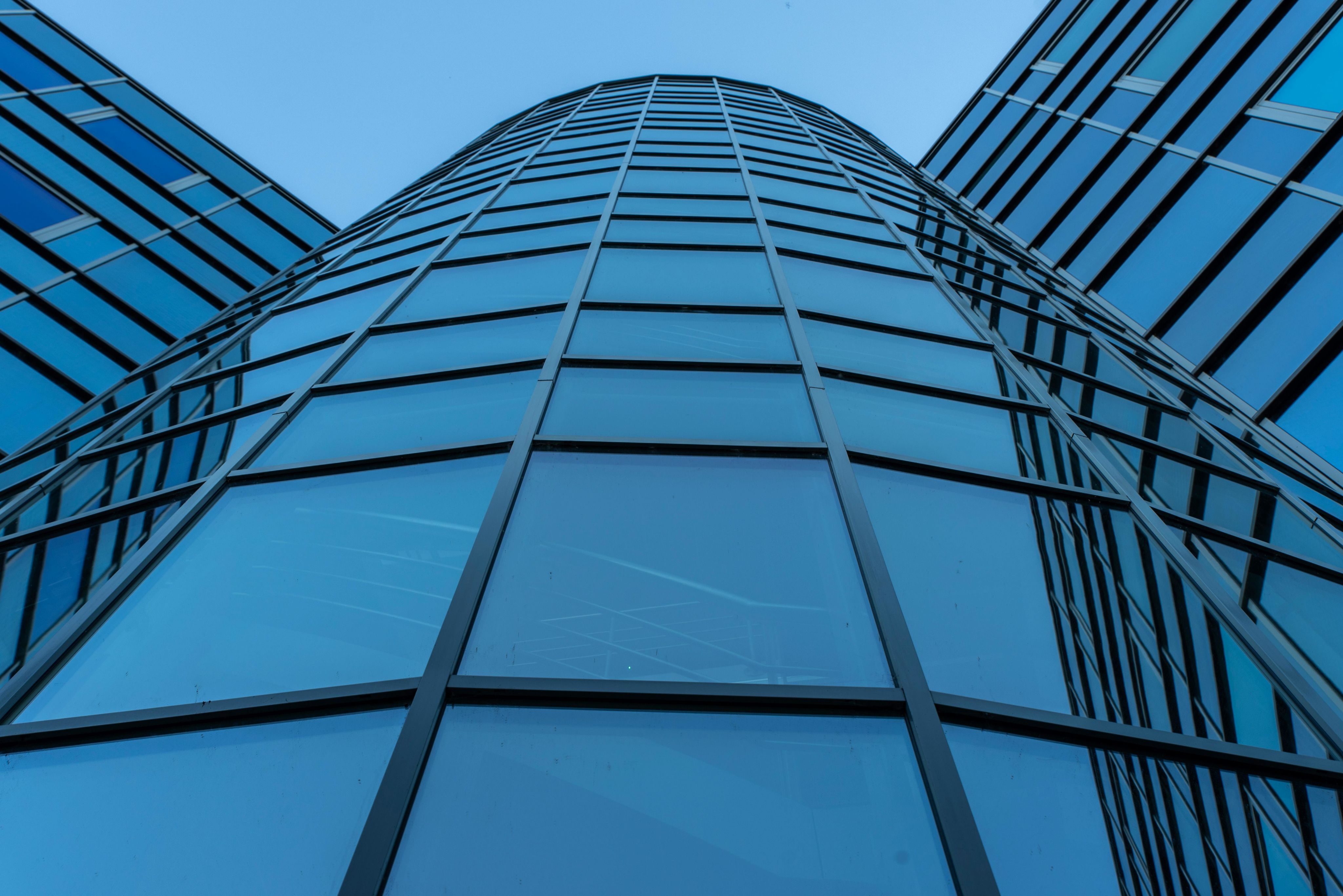 Dynamic view of a contemporary skyscraper facade with reflective glass panels.