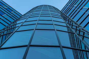 Dynamic view of a contemporary skyscraper facade with reflective glass panels.
